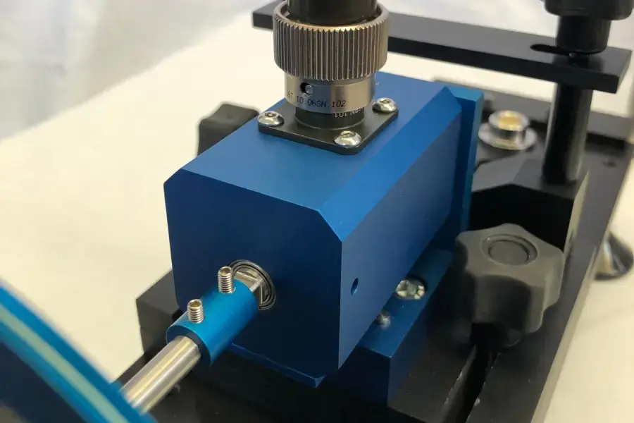 Blue inline torque transducer being calibrated on a torque rig