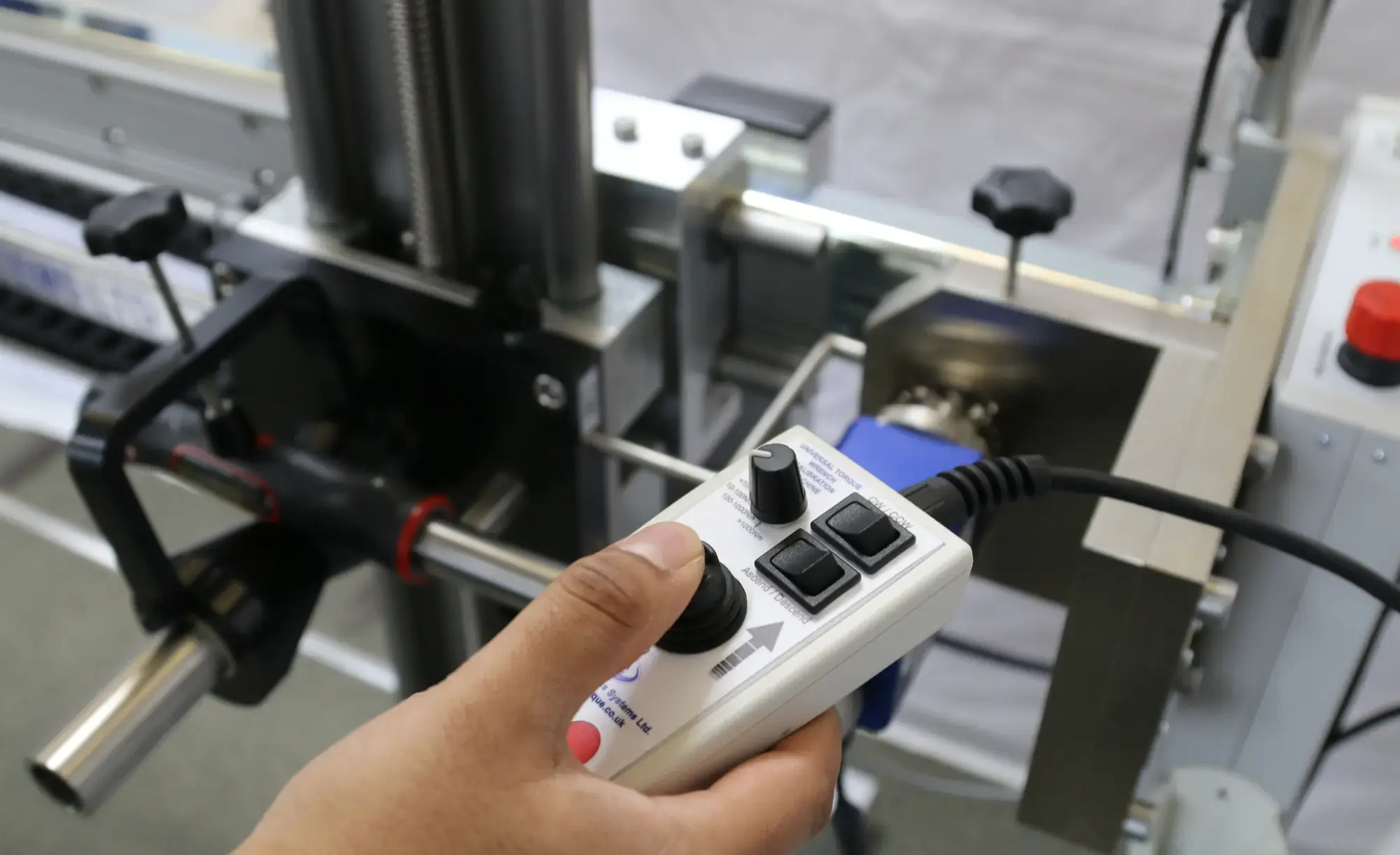 Man using a controller to control a torque wrench calibrator