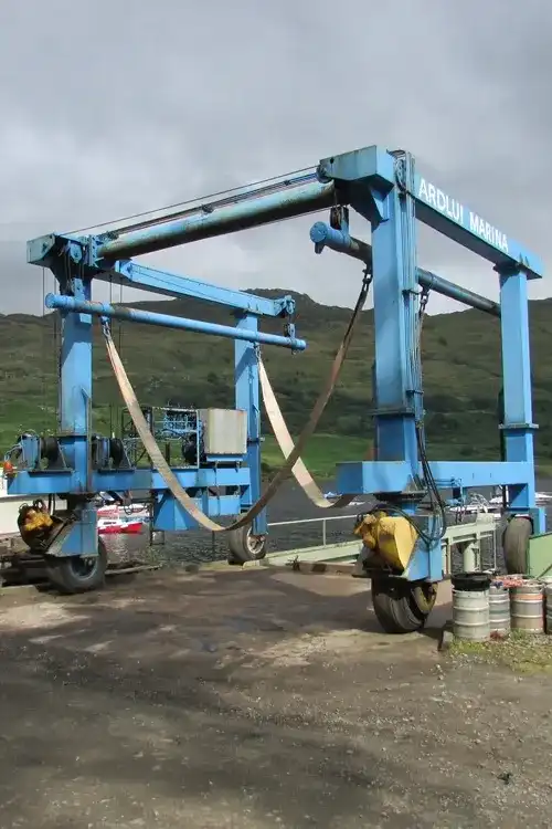 Blue boat hoist on side of river