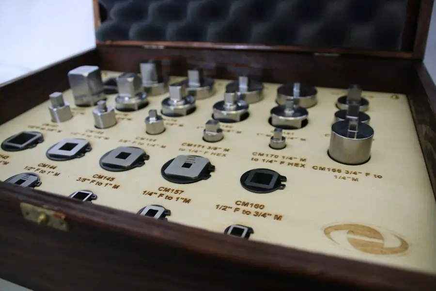 A set of torque adapters in a wooden container