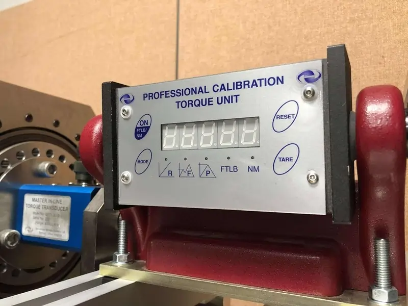 A close up of an AWS torque tester mounted on a calibration machine