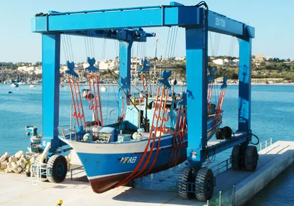Boat being lifted into water in a harbour